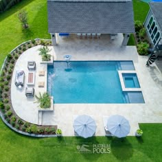 an aerial view of a swimming pool with lounge chairs and umbrellas