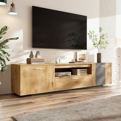 a living room with a large flat screen tv mounted on the wall above it's entertainment center