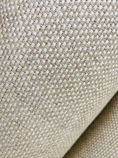 close up view of the texture of an upholstered fabric with white and beige colors