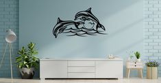 a room with blue walls and a white dresser in front of the wall is an image of two dolphins