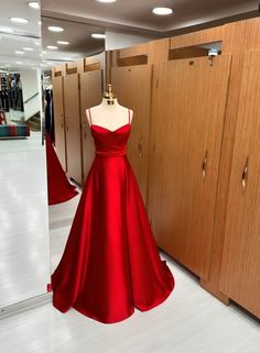 a red dress is on display in front of lockers and closets at a clothing store