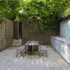 a wooden table and bench sitting in the middle of a yard