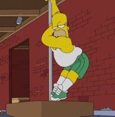 the simpsons is hanging upside down on a pole in front of a red brick wall