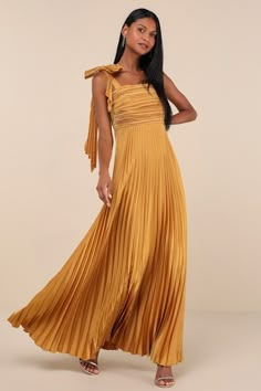 a woman in a yellow dress posing for the camera