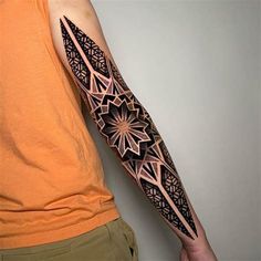 a man's arm with an intricate tattoo design on the left forearm and shoulder