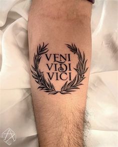 a man with a tattoo on his leg that reads veni vidi vici