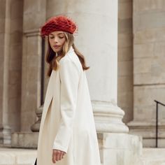 a woman wearing a white coat and red hat