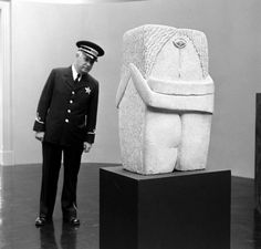 a man in uniform standing next to a statue