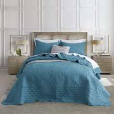 a bed with blue comforter and pillows in a room