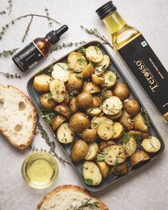 potatoes and bread on a table with an olive oil bottle next to it, along with other ingredients