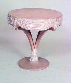 a pink table with white trim around the edge and an oval shaped base on top