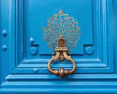 a blue door with an ornate handle on it