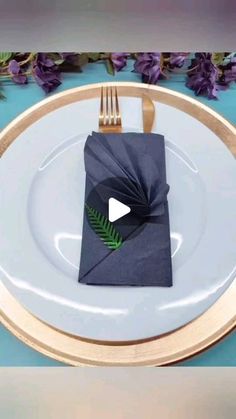 a white plate topped with a black napkin and a green leaf on top of it