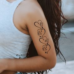 a woman with a tattoo on her arm that has hearts and words written in it