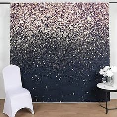 a white chair sitting in front of a black and white wall with glitter on it