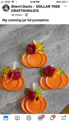 four orange plates with flowers on them sitting on top of a marble table next to candles