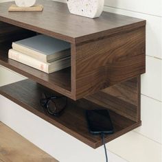 a wooden shelf with some books and a phone on it