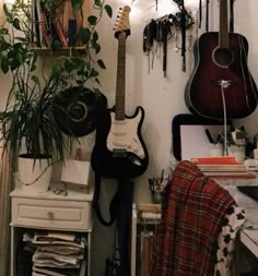 there is a guitar and other musical instruments on the wall in this room with plants