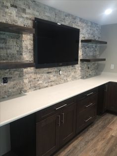 a large flat screen tv mounted to the side of a wall in a home kitchen