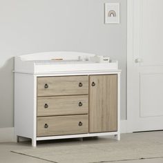 a baby crib with drawers and changing table next to it in a white room