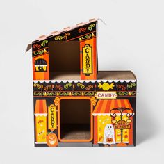 an orange and black cardboard candy shop with halloween decorations on the front, inside and out