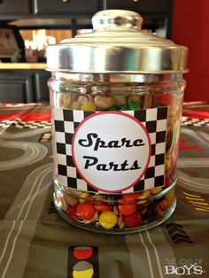 a jar filled with candy sitting on top of a table next to a black and white checkered table cloth