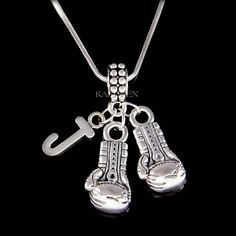 a silver necklace with two boxing gloves and a key hanging from it's side