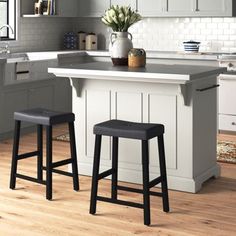 two stools sit at the center of a kitchen island