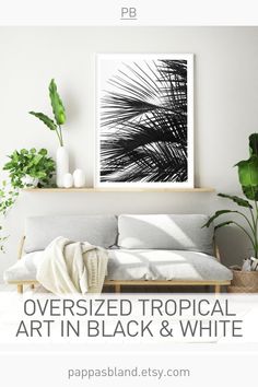 a living room with white walls and plants on the shelf, text overlay reads oversized tropical art in black and white