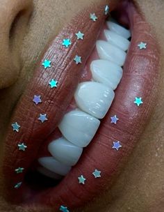 a woman's mouth with stars painted on it