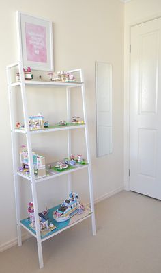 a white shelf filled with toys in a room