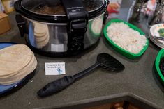 an assortment of food is displayed on the counter top in front of a crock pot