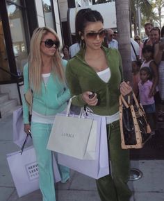 two women walking down the street carrying shopping bags