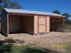 a small shed sitting on top of a dirt field