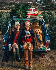 two women and a child sitting in the back of a car with their dog on christmas tree farm