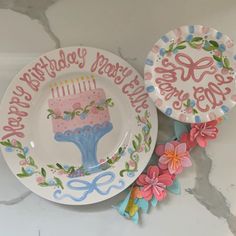 two plates with birthday designs on them sitting next to each other