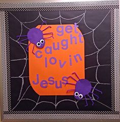 an orange and black sign with purple spider on it that says get caught in jesus