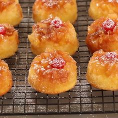 small pastries are cooling on a wire rack with powdered sugar and jelly toppings