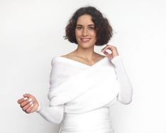 a woman in a white dress posing for the camera with her hands on her hips