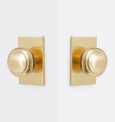 an image of a door handle on a white wall with gold handles and knobs