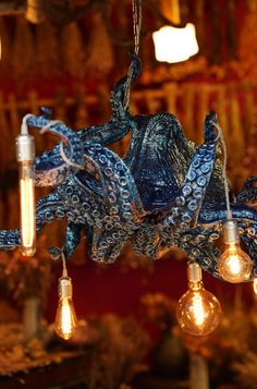 an octopus chandelier hanging from the ceiling with bulbs in it's mouth