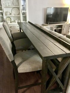 a dining room table with chairs and a television in the background