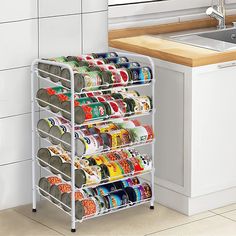 a kitchen rack filled with lots of canned food items next to a sink and counter top