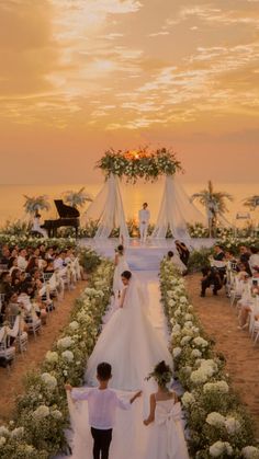 a bride and groom walking down the aisle at their wedding ceremony in front of an ocean view