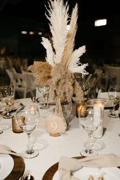 the table is set with white linens, silverware and tall pamodia