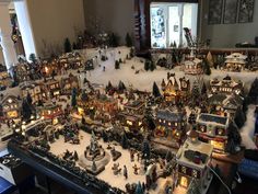 a christmas village is shown in the middle of a living room with snow on the ground