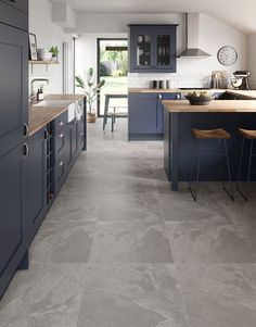 a large kitchen with blue cabinets and counter tops in an open floorplan area