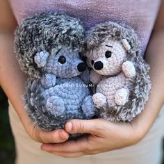 two crocheted stuffed animals are held in their hands