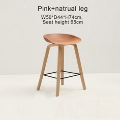 the pink - natural leg stool with wooden legs is shown in front of a white background