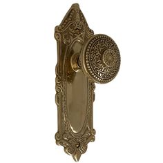 an ornate brass door handle on a white background